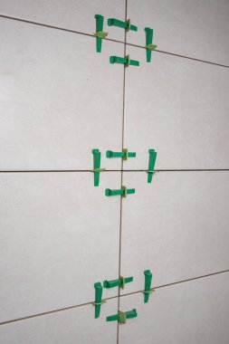 Fayans harcı ayarlanırken plastik klipsli ve takozlu döşeme sistemi