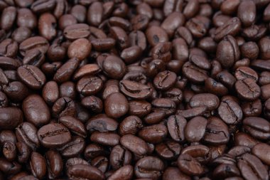 Kahve fasülyesi geçmişi. Tüm yüzeyde kavrulmuş kahve çekirdekleri. Kahverengi kahve. Üst görünümü olan düz bir düzen.