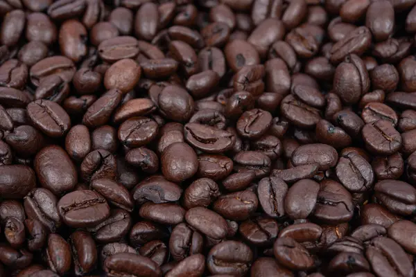 Kahve fasülyesi geçmişi. Tüm yüzeyde kavrulmuş kahve çekirdekleri. Kahverengi kahve. Üst görünümü olan düz bir düzen.