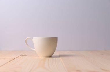 Beyaz arka planda, tahta masada beyaz bardakta sıcak içecekler..