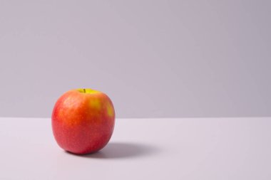 Beyaz arkaplanda gölgesi olan bir elma.