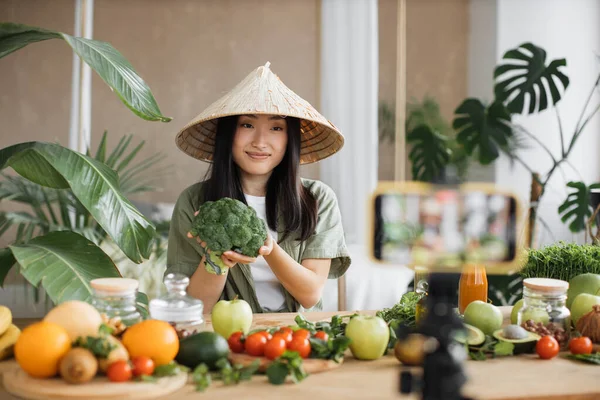 アジアの女性は 熱帯リゾートキッチンスタジオでソーシャルメディアのビデオコンテンツを作成する電話を使用して健康的な食べ物を作っています ブロッコリーを使用した美しい女性 健康的なサラダを準備野菜や果物 — ストック写真