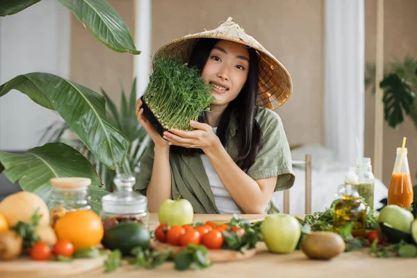 伝統的な円錐形の帽子の楽しいアジアの女性は 熱帯リゾートのエキゾチックな光スタジオで健康的なディナーを楽しんで野菜の果物やマイクログリーンのもやしサラダを作ります 減量のための食品や栄養 — ストック写真
