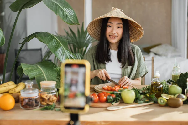아시아인 블로거나 제작자는 샐러드를 준비하고 휴대폰으로 동영상을 스마트폰으로 블로그를 기록하면서 — 스톡 사진