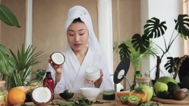 Junge Asiatin Weißem Bademantel Und Handtuch Mit Einer Halben Kokosnuss — Stockvideo