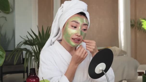Havlu Bornozlu Güzel Asyalı Kadın Yeşil Kozmetik Maskeyi Yüzünden Çıkartıyor — Stok video
