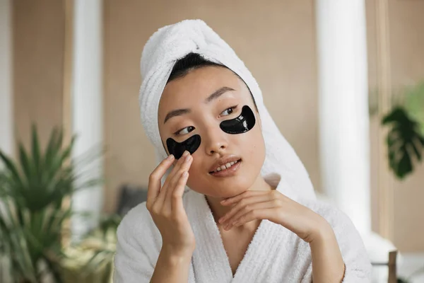 Przyjemna Azjatka Białym Szlafroku Ręczniku Przepaskami Oczy Zabiegów Kosmetycznych Egzotycznym — Zdjęcie stockowe
