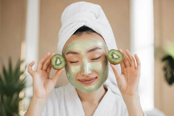 Egészséges Gyönyörű Fiatal Ázsiai Zöld Kozmetikai Maszkkal Kivivel Kezében Egzotikus — Stock Fotó