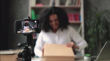 Akıllı telefon ekranına odaklan. Yeni kablosuz tabletle kutuları açarken kameraya video kaydeden kadın. Abonelerle kadın etkileri paylaşan kişi, yeni düzen hakkındaki olumlu görüşlerini paylaşıyor.
