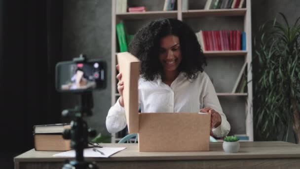 Wielokulturowa Kobieta Nagrywa Wideo Kamerze Telefonicznej Podczas Rozpakowywania Pudełka Nowym — Wideo stockowe
