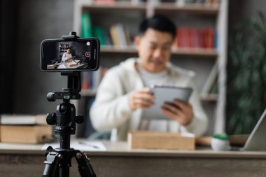 Akıllı telefon ekranına odaklan, yeni kablosuz tabletle kutuları açarken kameraya video kaydet. Erkek nüfuzlu kişi, abonelerle yeni düzen hakkındaki olumlu görüşlerini paylaşıyor..