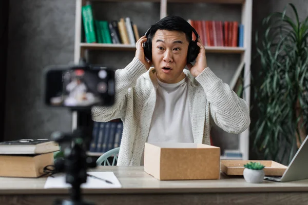 Asyalı Adam Yeni Kablosuz Kulaklıklarla Kutuları Açarken Telefon Kamerasına Video — Stok fotoğraf
