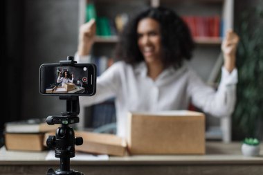 Çok uluslu, sıradan bir kadın hediye paketini açarken kameraya kayıt videosu takıyor. Kadın blogcu duygularını sosyal ağlardaki aboneleriyle paylaşıyor.