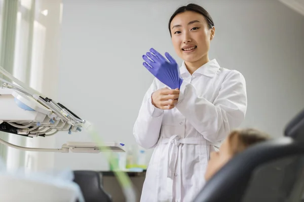 Güzel Asyalı Kadın Dişçi Mavi Lastik Eldivenlerini Giyer Dişçi Ofisinde — Stok fotoğraf