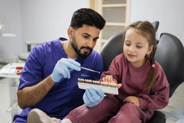 Młody Profesjonalny Brodaty Dentysta Wybiera Kolor Wypełnienia Palety Dla Małej — Zdjęcie stockowe