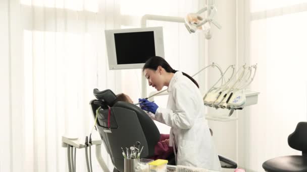 Красивая Улыбка Белыми Зубами Азиатский Стоматолог Лечит Зубы Молодой Красивой — стоковое видео