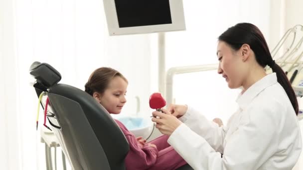 Vista Lateral Jovem Muito Asiático Dentista Pediátrico Mostrando Pequena Menina — Vídeo de Stock