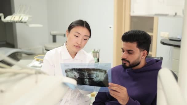 Привабливий Молодий Бородатий Чоловік Сидячи Стоматологічному Стільці Дивлячись Рентгенівське Зображення — стокове відео