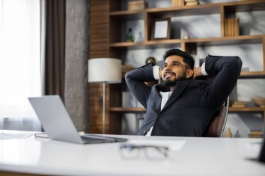 Gözlüklü, kendine güveni tam iş yerinde rahatlayan, şekerleme yapan ya da hayal kuran bir adam. Mutlu, rahat, Kafkasyalı genç erkek koltukta dinleniyor. Dikkati bilgisayar başında değil, negatif duyguları yatıştırıyor..
