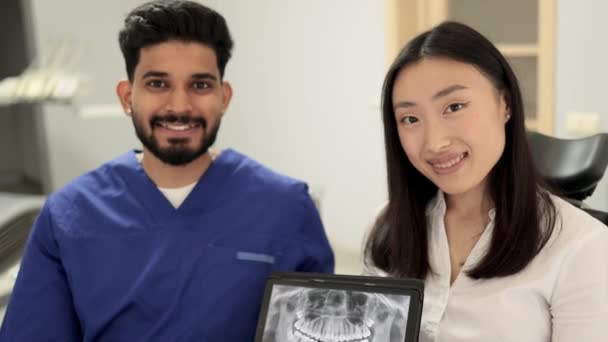 Leende Glad Asiatisk Kvinna Besöker Självsäker Skäggig Tandläkare Sitter Tandstol — Stockvideo