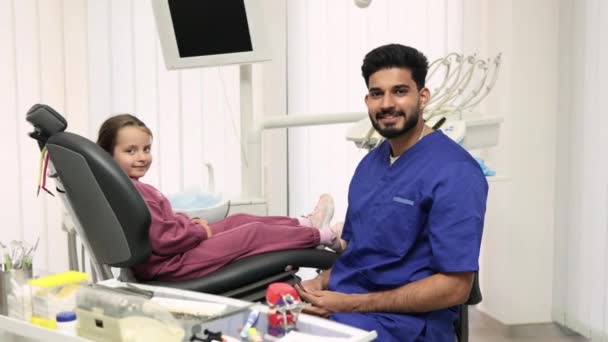 Behandlung Von Kinderzähnen Lächelndes Kleines Mädchen Das Zahnarztstuhl Der Leichten — Stockvideo