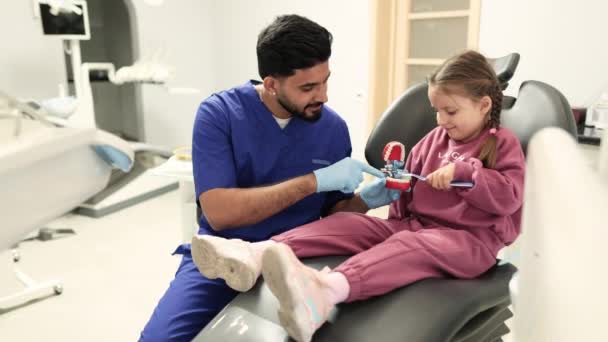 Felice Dentista Maschio Fiducioso Dice Alla Bambina Come Lavare Denti — Video Stock
