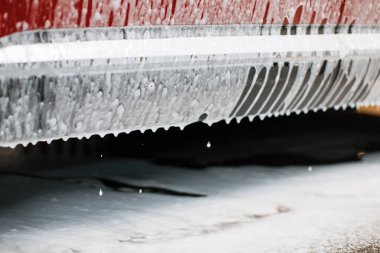 Oto yıkama servisinde araba eşiğini yıkıyorum. Sabunlu kırmızı araba. Aktif temizlik köpüğüyle çapraz araba yıkama, araba sabunlu kaputunun ön görüntüsü..