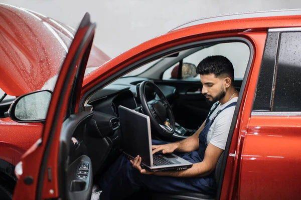자동차 안에서 노트북을 사용하여 차안에 자동차 점검을 기술자는 자동차 작업장에서 — 스톡 사진