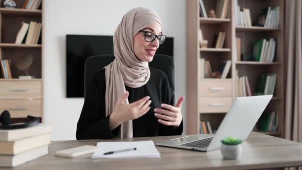 Smiling Muslim Businesswoman Having Video Conversation While Sitting Table Working — Αρχείο Βίντεο