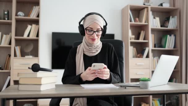 Beautiful Young Muslim Woman Headphones Listening Music Using Phone Sitting — Stockvideo