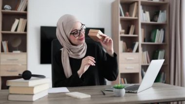 Arabian female blogger sharing her feedback about modern gadget with her subscribers. Muslim woman doing live stream while unpacking box with new smart watch.
