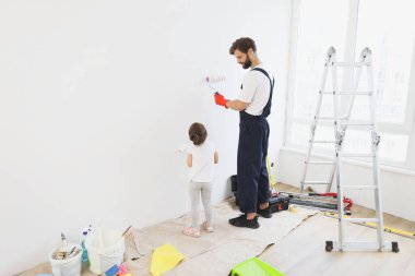 Duvarları boyarken genç babasının ve küçük tatlı kızının uzun bir portresi..