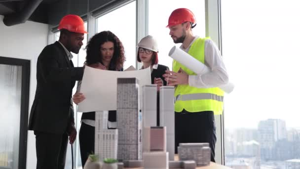 都市モデル 青写真を読む多文化労働者に焦点を当てます 住宅街やビジネス街の複雑なプロトタイププロジェクトの構築に取り組む建築家 デザイナー エンジニア — ストック動画