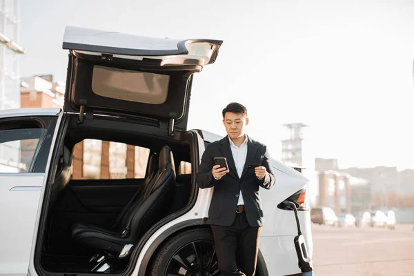 Orang Asia Fokus Dalam Pakaian Bisnis Berdiri Dekat Pengisian Mobil — Stok Foto