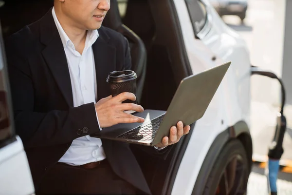 Fokuserad Asiatisk Man Kostym Dricka Kaffe Och Arbetar Laptop Medan — Stockfoto