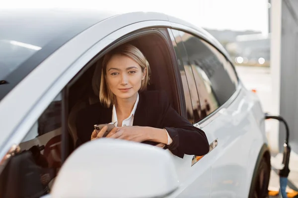 Aantrekkelijke Blanke Vrouw Met Moderne Smartphone Handen Zitten Luxe Auto — Stockfoto