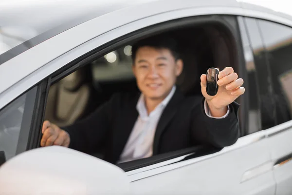 Zamazane Tło Uśmiechniętego Azjatyckiego Biznesmena Czarnym Garniturze Siedzącego Nowym Samochodzie — Zdjęcie stockowe