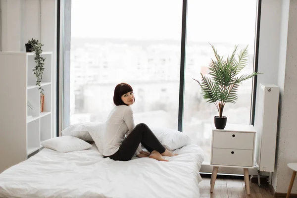 Приваблива Біла Жінка Домашньому Вбранні Відпочиває Білому Ліжку Панорамними Вікнами — стокове фото