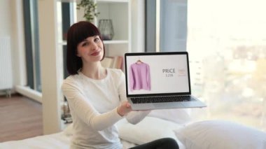 İnternette% 15 indirimle satılan modaya uygun kıyafetlerle ekranda avuç içi gösteren beyaz bir kadın. Dış ticaret, insanlar ve teknoloji kavramı.