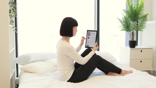 Koyu Renk Saçlı Beyaz Kadının Internet Sitesinde Dijital Tablet Kullanarak — Stok video