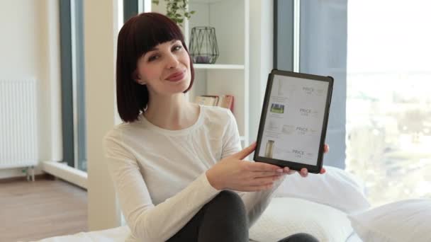머리카락을 긍정적 코카서스 침대에 디지탈 태블릿을 손으로 가리키고 온라인 상점에서 — 비디오