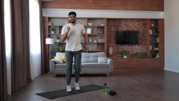Jóképű Arab Férfi Rövid Ruhában Aktív Fitnesz Gyakorlatokat Végez Nappaliban — Stock videók
