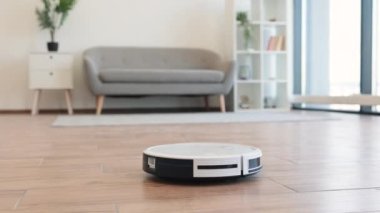 Otomatik robot süpürgesi oturma odasındaki tozu kaldırırken yumuşak halıdan parke döşemeye geçiyor. Akıllı ev cihazı günlük süpürme ve sakinleri mevsimsel alerjilerden koruyor..