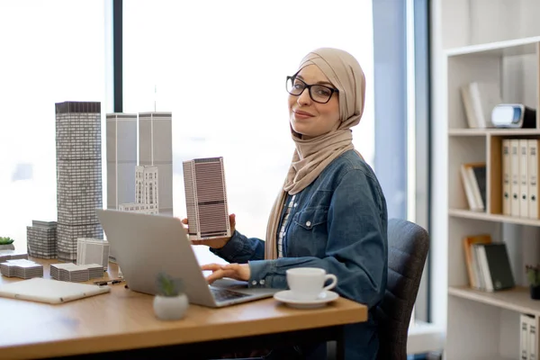Радісна Мусульманка Носить Хіджаб Окуляри Друкуючи Ноутбуці Тримаючи Архітектурну Модель — стокове фото