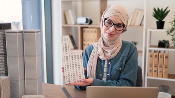 Радісна Мусульманка Носить Хіджаб Окуляри Друкуючи Ноутбуці Тримаючи Архітектурну Модель — стокове відео