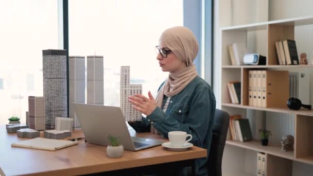 Atrakcyjna Arabska Bizneswoman Nosząca Hidżab Trzymająca Wielopiętrowy Model Budynku Siedząc — Wideo stockowe