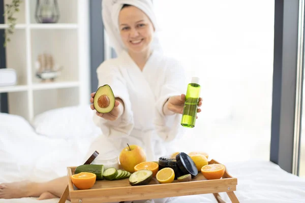 Uśmiechnięta Kobieta Stroju Prysznicu Prezentująca Zielone Awokado Olejku Owocowym Kosmetycznym — Zdjęcie stockowe