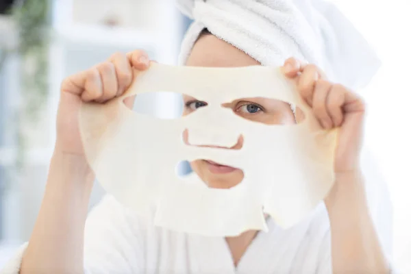 Okouzlující Běloška Bílém Županu Ručníku Dívající Dírami Kosmetické Prostěradlové Masce — Stock fotografie