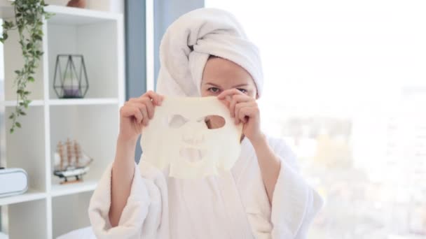 Wesoły Zrelaksowany Kobieta Stroju Prysznicu Pomocą Maski Tkankowej Twarzy Podczas — Wideo stockowe