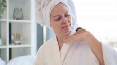 Kafasında banyo havlusu olan beyaz kadın, arka planda bir elden diğerine sürünen büyük salyangoza bakıyor. Güzel bir kadın hafta sonu tatlı bir hayvanla güzellik terapisinden zevk alıyor..